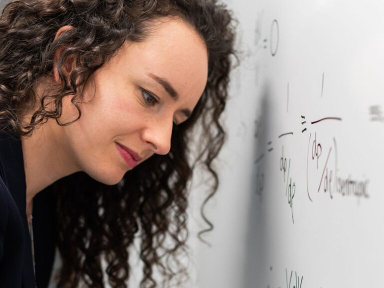 Woman writing on a clean white dry-erase surface
